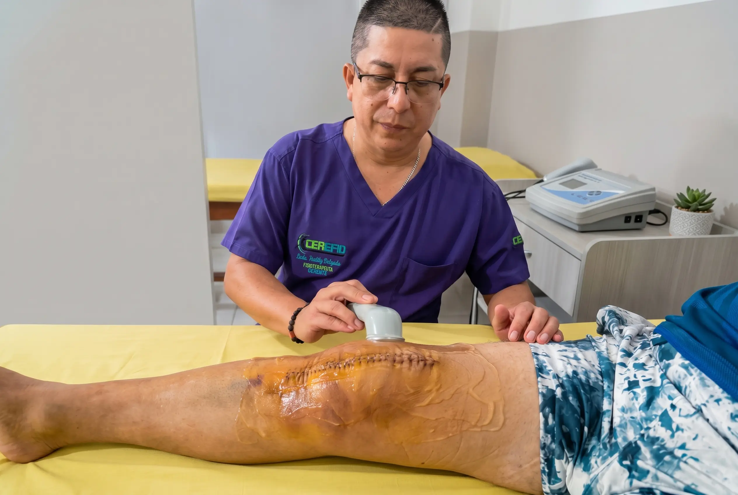 Fisioterapeuta aplicando ultrasonido terapéutico en rodilla en proceso postoperatorio.